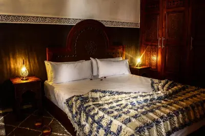 a bed in a bedroom with two lamps on tables at Astra Damus Hotel in Marrakech