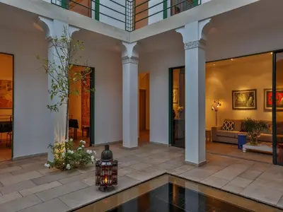 a lobby with a pool in the middle of a building at Riad Oasis 3 in Marrakech