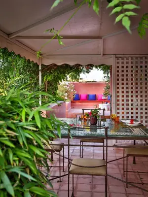 a patio with a table and chairs and a couch at Riad Oasis 3 in Marrakech