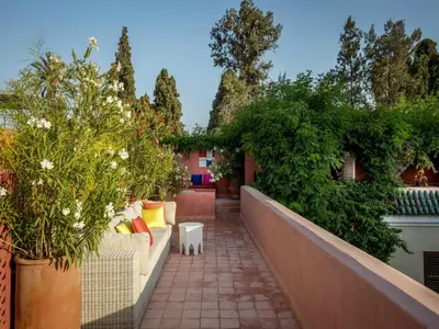 a patio with a couch and some plants at Riad Oasis 3 in Marrakech