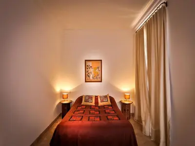 a bedroom with a bed and two lamps on two tables at Riad Oasis 3 in Marrakech