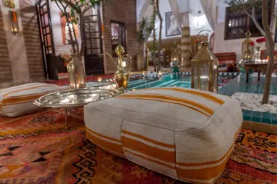 a room with a pool with a table and chairs at Riad Dar Yema in Marrakech