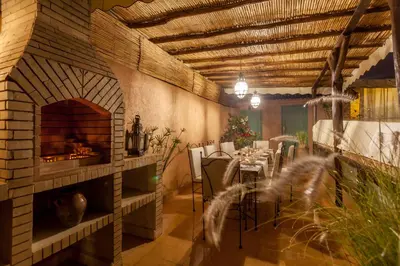 a dining room with a fireplace and a table and chairs at Riad Dar Yema in Marrakech