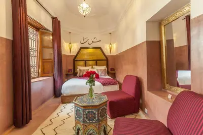 a bedroom with a bed and a vase of flowers on a table at Riad Dar Yema in Marrakech
