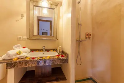 a bathroom with a sink and a mirror and a shower at Riad Dar Yema in Marrakech