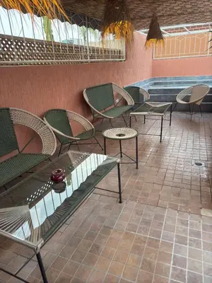 a group of chairs and tables next to a pool at Riad Dihya in Marrakech