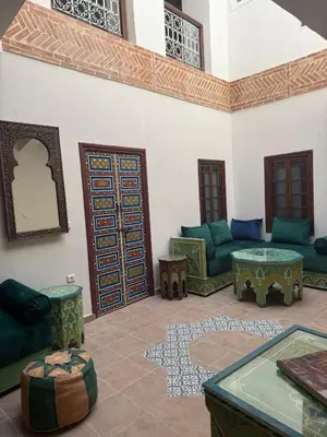 a living room with green furniture and a large door at Riad Dihya in Marrakech