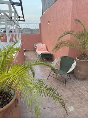 a patio with two chairs and plants on a building at Riad Dihya in Marrakech