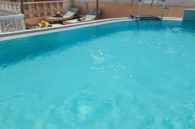 a large pool with blue water in a hotel at Riad Ayni in Marrakech
