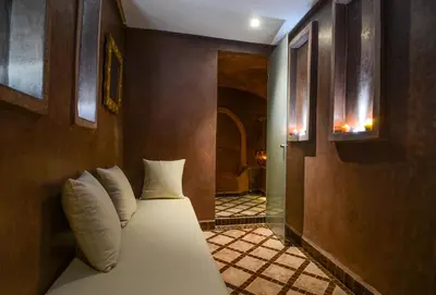 a bedroom with a bed with white pillows at Riad Ayni in Marrakech