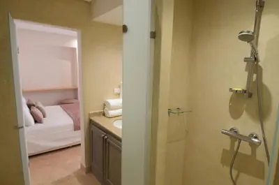a bathroom with a shower and a sink and a bed at Riad Ayni in Marrakech