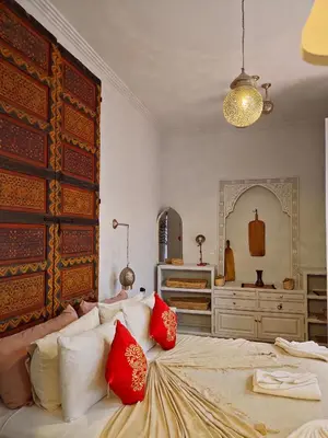 a bedroom with a large bed with red pillows at Riad Laly Tourisme Eclairé Le bijou de la medina in Marrakech