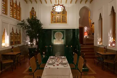 a dining room with a table in the middle of it at Riad Andallaspa in Marrakech
