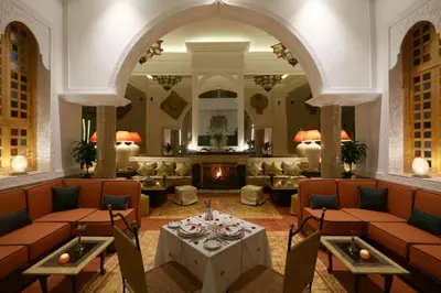 a lobby with a table and chairs and a fireplace at Riad Andallaspa in Marrakech