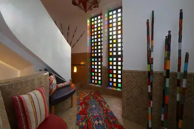 a living room with a couch and stained glass windows at Riad Andallaspa in Marrakech