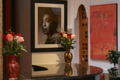 a picture of a man with flowers in a vase on a table at Riad Andallaspa in Marrakech