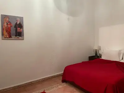 a bedroom with a red bed and a picture on the wall at Riad Safia in Marrakech