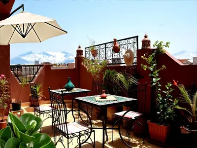 a patio with two tables and chairs on a balcony at Dar Yasser in Marrakech
