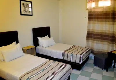 a hotel room with two beds and a window at Dar Yasser in Marrakech