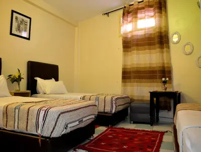 a hotel room with two beds and a window at Dar Yasser in Marrakech