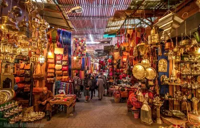 a market with people walking through a market with shops at Appartement Marrakech in Marrakech