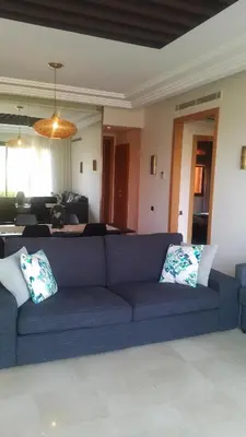 a living room with a blue couch with two pillows at Appartement Privé au Vizir Center Marrakech in Marrakech