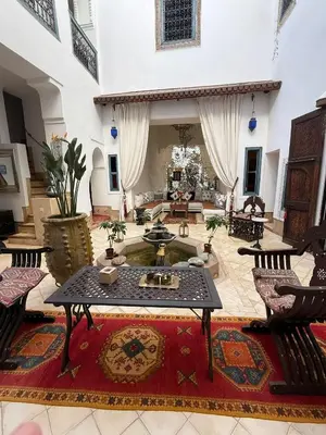 a large living room with a table and chairs at Riad Dar Oulhoum in Marrakech