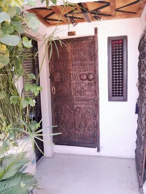 a large wooden door on the side of a building at Riad Dar Oulhoum in Marrakech