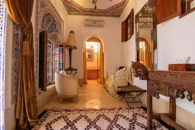 a hallway with a living room with a couch and a mirror at Riad Dar Oulhoum in Marrakech