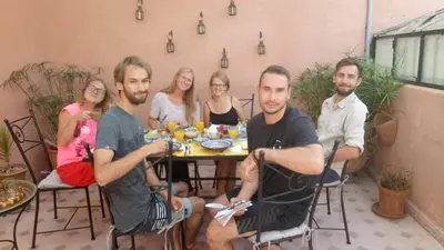 a group of people sitting around a table at Riad Majdoulina chez JIJI in Marrakech