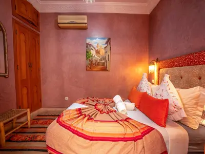 a bedroom with a large bed in a room at Riad Majdoulina chez JIJI in Marrakech