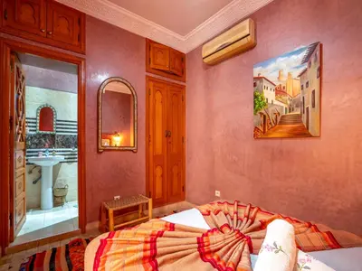 a bedroom with a bed and a sink at Riad Majdoulina chez JIJI in Marrakech