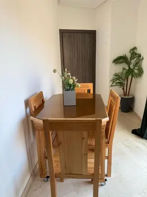 a wooden table and chairs with flowers on it at Appartement Nour Guéliz Marrakech in Marrakech