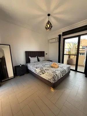 a bedroom with a bed and a television in it at Appartement Nour Guéliz Marrakech in Marrakech