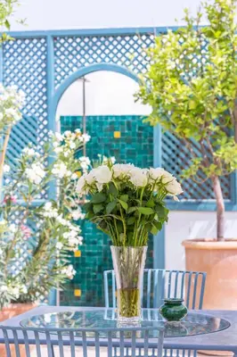 a vase filled with white flowers sitting on a table at Riad Azahar in Marrakech