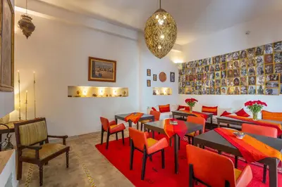 a restaurant with tables and chairs and a chandelier at Riad Azahar in Marrakech