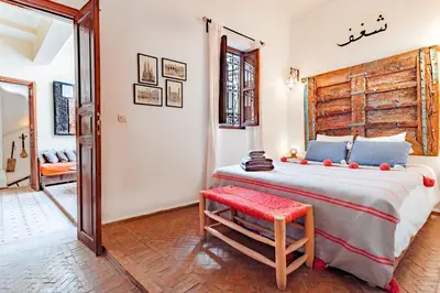 a bedroom with a large bed and a red stool at Color Safrà in Marrakech