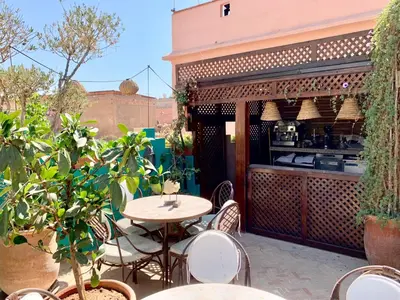 an outdoor patio with a table and chairs and a kitchen at Color Safrà in Marrakech