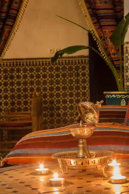 a table with candles and a clock on top of it at Riad Tiziri in Marrakech