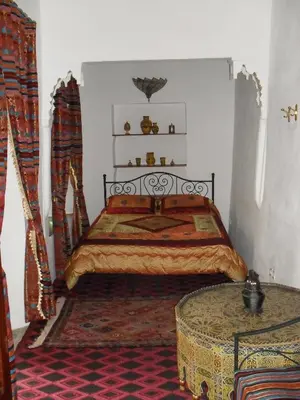 a bedroom with a bed and a table in it at Riad Tiziri in Marrakech