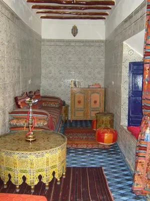 a room with two beds and a table in it at Riad Tiziri in Marrakech