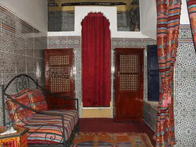 a room with a bed and a red curtain at Riad Tiziri in Marrakech