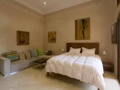 a bedroom with a large bed and a couch at Maison d'hote Oceania in Marrakech