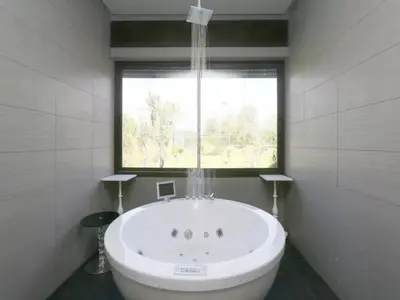a bathroom with a large bath tub with a window at Maison d'hote Oceania in Marrakech