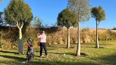 a man standing in a field next to two trees at Villa Jardins D'Isa in Marrakech