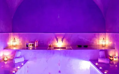 a purple room with a tub with candles and lights at Villa Jardins D'Isa in Marrakech