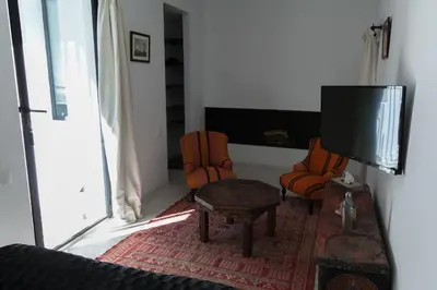 a living room with a tv and two chairs at Riad Zebrakaro in Marrakech