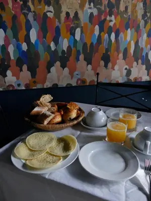a table with plates of food and a basket of bread at Riad Zebrakaro in Marrakech