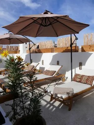 a group of chairs and an umbrella on a patio at Riad Zebrakaro in Marrakech