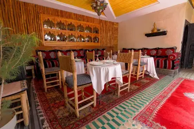 a restaurant with tables and chairs in a room at Riad Salma Restaurant Spa in Marrakech
